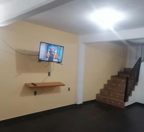 una camera con TV a parete e scale di casa 2 pisos tultitlan a Città del Messico