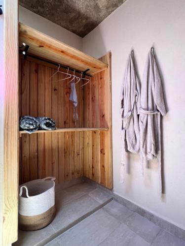 a bathroom with a wooden wall with a towel rack at CASAS LEON Casita de playa #2 in Santa Bárbara de Samaná