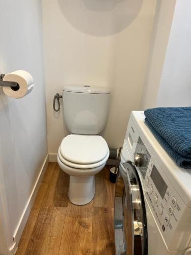 a bathroom with a toilet and a washing machine at Studio Beausoleil porte de Monaco in Beausoleil