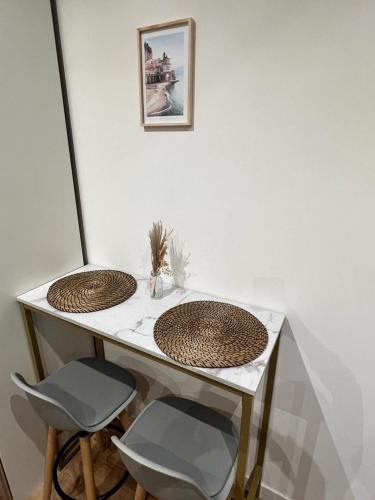 a table with two baskets on it with two chairs at Studio Beausoleil porte de Monaco in Beausoleil