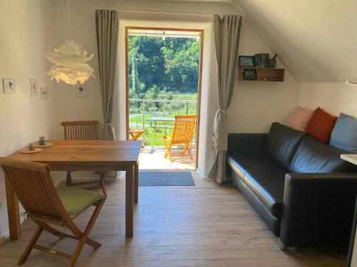 ein Wohnzimmer mit einem Sofa und einem Tisch in der Unterkunft Kleine-Radoase Ferienwohnung mit Super- Aussicht in Weilburg
