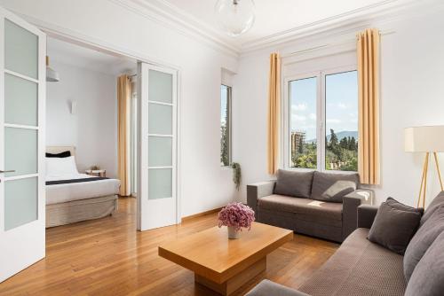 Acropolis Exclusive Residence في أثينا: غرفة معيشة مع أريكة وسرير