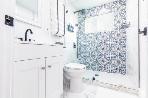 baño con aseo y papel pintado azul y blanco en Serenity Lodge Condo, en Miami