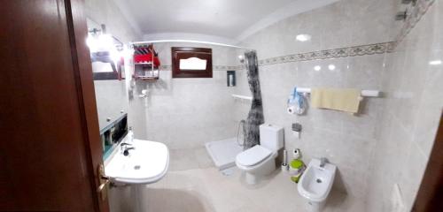 a white bathroom with a toilet and a sink at 2 bedrooms appartement with city view at Arrecife in Arrecife