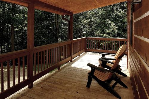 una mecedora sentada en un porche de madera en Mountain Laurel Cabin, en Cosby