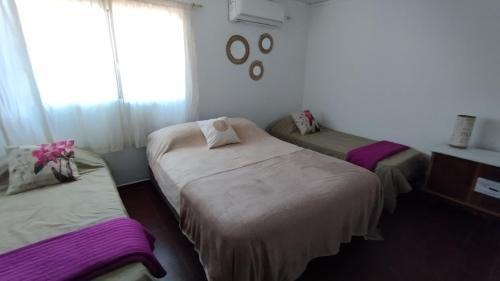 - une chambre avec 2 lits et une fenêtre dans l'établissement Casa para 6 y 1 garaje - Yerutí, à Posadas