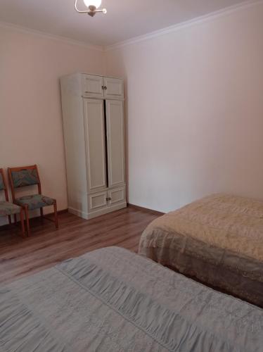a bedroom with a bed and a cabinet and a chair at BIG HOUSE in Dilijan
