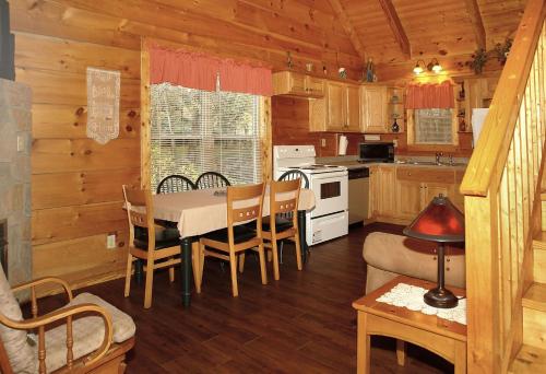 a kitchen and dining room with a table in a cabin at Jon's Pond in Cosby