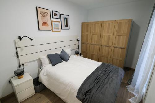 um quarto com uma grande cama branca com almofadas azuis em 0B PlusUltra piso de 1 dorm em Alicante
