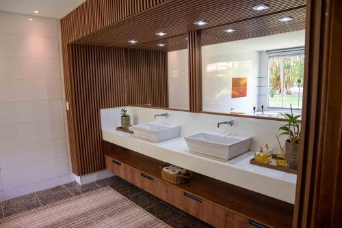 a bathroom with two sinks and a large mirror at Spa Agua Milagrosa in Cuiabá