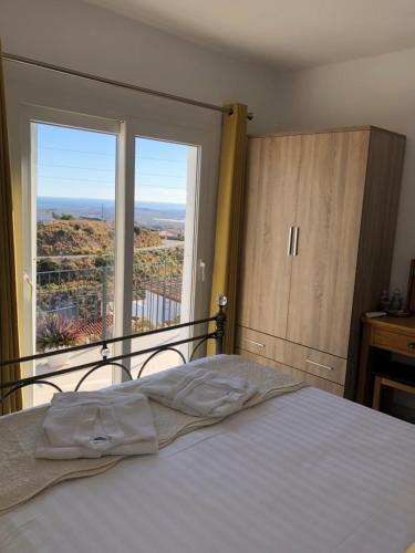 um quarto com uma cama e uma grande janela em Casa Miramar, with private pool, jacuzzi and stunning views em Bédar