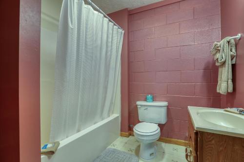 a pink bathroom with a toilet and a sink at Into the Wild Cabin in Cosby