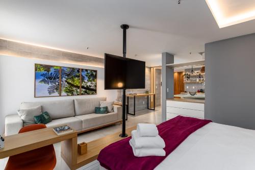 ein Schlafzimmer mit einem Bett und einem Sofa sowie eine Küche in der Unterkunft Estúdio sofisticado no Flamengo - CZL505 Z5 in Rio de Janeiro