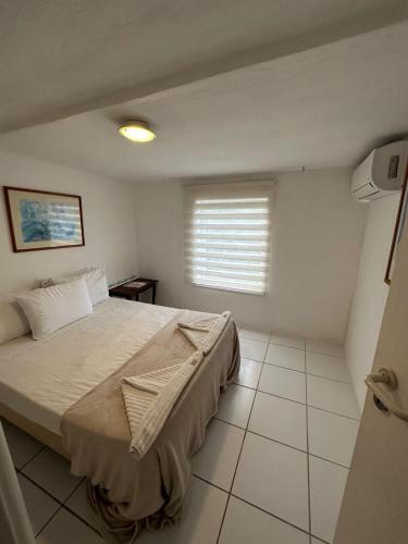 a bedroom with a large bed and a window at Pousada Vista Grega in Arraial do Cabo