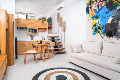 a living room with a couch and a table at KARRA LOFT - Bali Invest Club in Canggu