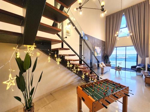 salon ze szklanym stołem do gry w piłkarzyki i schodami w obiekcie Loft Suite Seaview JB CIQ 7Pax w mieście Johor Bahru
