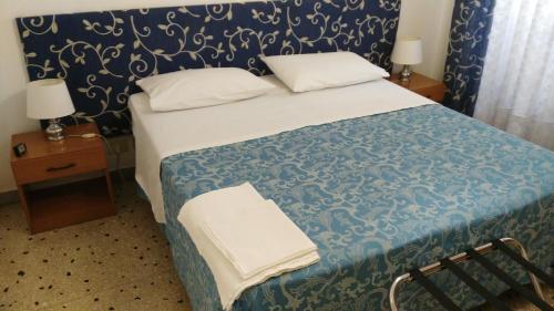 - une chambre dotée d'un lit avec une couverture bleue et blanche dans l'établissement Trionfal Apartment, à Rome