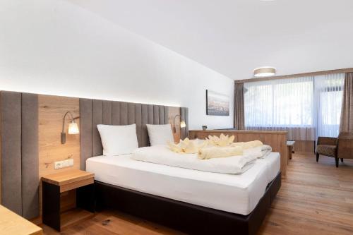 een slaapkamer met een groot bed met witte kussens bij Appartement Krippenstein mit Indoorpool und Sauna in Bad Goisern