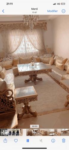 ein Wohnzimmer mit einem Sofa und einem Tisch in der Unterkunft Hay agdal oujda in Oujda