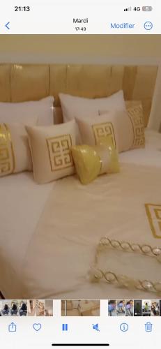 ein Bild eines Bettes mit weißen und gelben Kissen in der Unterkunft Hay agdal oujda in Oujda