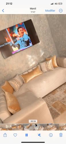 einen TV auf einer Couch mit Kissen in der Unterkunft Hay agdal oujda in Oujda