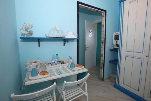 a blue room with a table and chairs and a mirror at Le Nereidi BeB in Margherita di Savoia