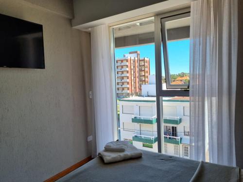 a bedroom with a window with a view of a building at View Beach in Villa Gesell