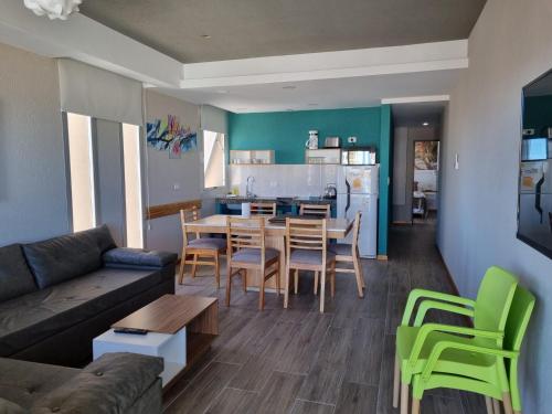 a living room with a couch and a table and chairs at View Beach in Villa Gesell