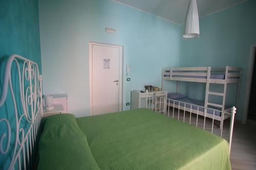 a bedroom with a green bed and bunk beds at Le Nereidi BeB in Margherita di Savoia