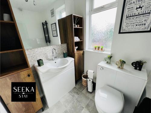 a bathroom with a white toilet and a sink at Greenwood in Coventry