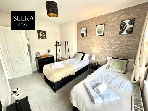1 dormitorio con 2 camas y un cartel que lee la estancia sekka en Cosy 2-bedroom house, Walking distance CBS, Ideal for contractors-business stays, en Coventry