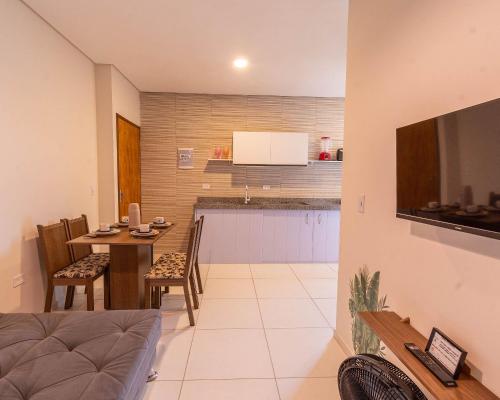 a living room and kitchen with a table and chairs at Flats Mar'Bella A melhor Localização com Varanda, Cozinha, Estacionamento e Home Office a 100M praia Barra Grande/Maragogi in Maragogi