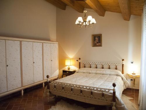 a bedroom with a bed and a chandelier at Terra Del Sole in Recanati