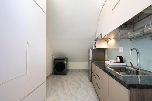 a small kitchen with a sink and a microwave at F-APARTMENT in Ho Chi Minh City