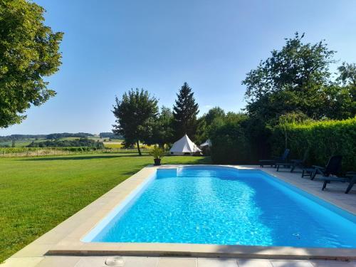 - une piscine dans une cour avec une tente en arrière-plan dans l'établissement Bellevues Glamping and Camping, à Mérignac