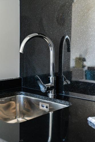 - un évier de cuisine avec deux robinets installés sur un comptoir dans l'établissement Joli Studio Champagne au Mont d'or, à Champagne-au-Mont-dʼOr