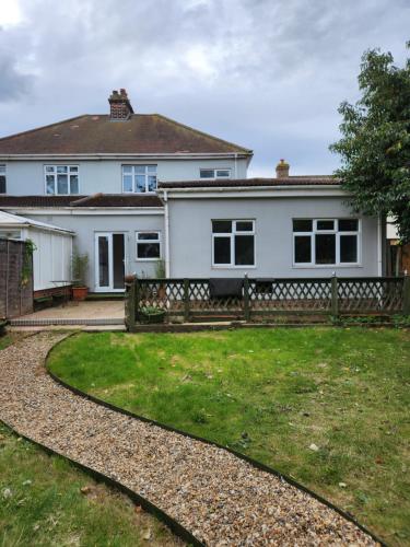 a white house with a fence and a yard at Chi Lodge & Accommodation in Rainham