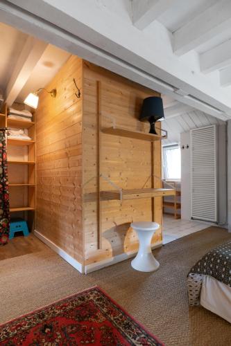 Cette chambre est dotée d'un mur en bois, d'un lit et d'une table. dans l'établissement Grande Maison Creuzier - Villa 3 chambres et jardin, à Creuzier-le-Neuf