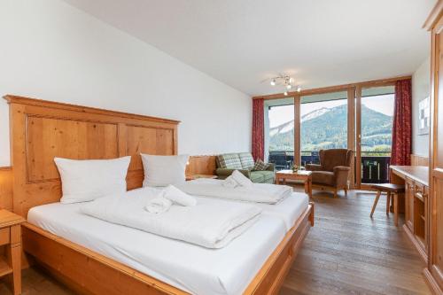 um quarto com uma cama grande e lençóis brancos em Appartement Predigstuhlblick mit Indoorpool und Sauna em Bad Goisern