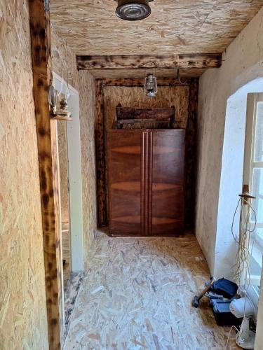 una grande porta in legno in una stanza con un muro di Jana's old house a Virpazar