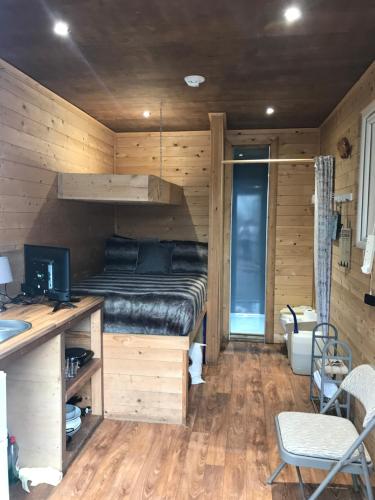 a bedroom with a bed and a desk with a computer at Ogdenclough fisherie log cabin in Rochdale