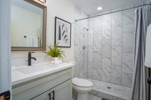 a bathroom with a toilet and a sink and a shower at Brand New Craftsman 2BR2BA Home in Denver Heights in San Antonio