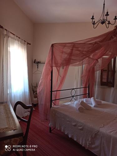 a bedroom with a bed with a pink canopy at Lefkara Hotel in Pano Lefkara