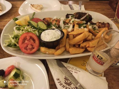 a plate of food with french fries and a salad at Lefkara Hotel in Pano Lefkara