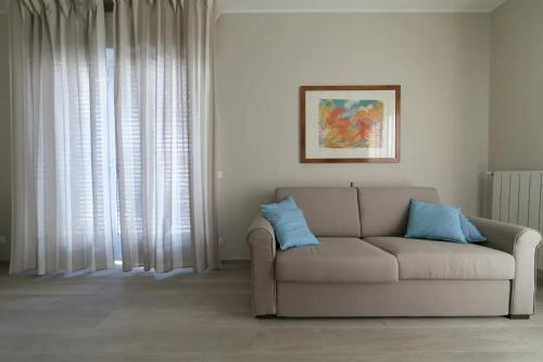 a living room with a couch with two blue pillows at CasaViva - Blue Penthouse with parking in Santa M in Santa Margherita Ligure