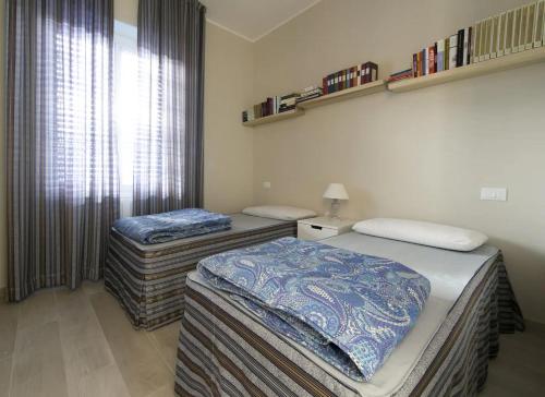 two twin beds in a room with a window at CasaViva - Blue Penthouse with parking in Santa M in Santa Margherita Ligure
