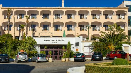 un grand bâtiment avec des voitures garées dans un parking dans l'établissement Hotel Sol e Serra, à Castelo de Vide