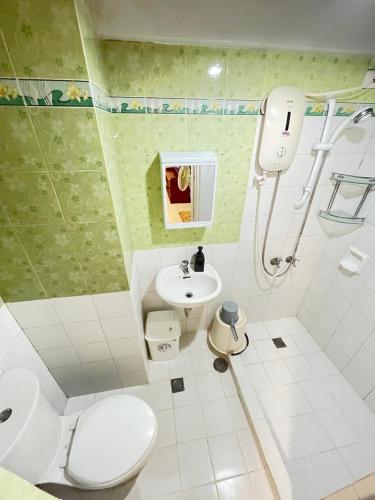 La salle de bains est pourvue d'une douche, de toilettes et d'un lavabo. dans l'établissement AZ Suites 2 bedroom Camella Northpoint, à Davao