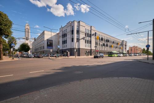 eine leere Stadtstraße mit einem weißen Gebäude in der Unterkunft Center stay Kaunas - Peledyne - Owl's nest apartments in Kaunas