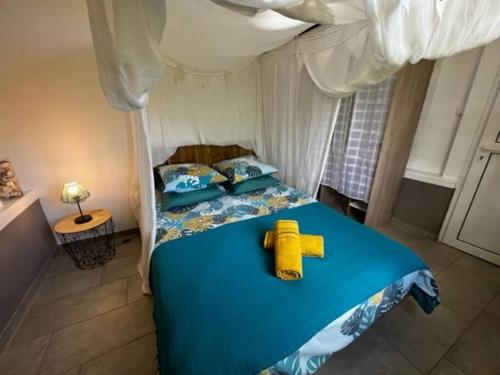 sypialnia z łóżkiem z żółtą zabawką w obiekcie PAVILLON TI GEMME LE DIAMANT w mieście Le Diamant